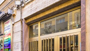 A building with a large, barred entrance and a sign indicating a business related to car rentals. - Chiave di Fuga - Tripla Superior - Camera 2 (Naples)