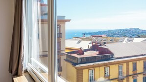 A room with a large window overlooking a cityscape and the sea. - Chiave di Fuga - Doppia Superior -  Camera 4 (Naples)