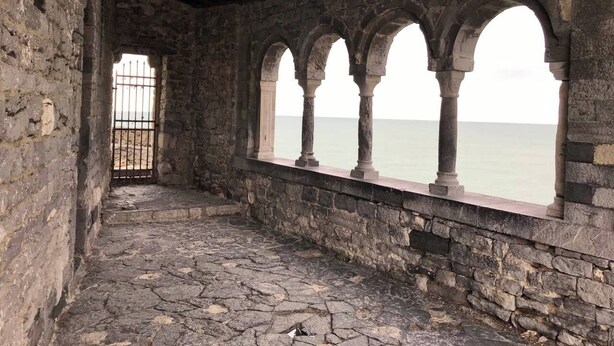 A stone corridor with arches leading to a gated entrance and a view of the sea. - The Traveler's House   (N. CITRA 011015-LT-1230) (La Spezia)
