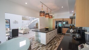 A modern kitchen with a central island, built-in appliances, and pendant lighting. - Entire home with Pool. Walk to the beach. Lety Copel (Mazatlan)