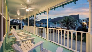 A covered porch with white chairs and a view of neighboring houses. - 2nd Row, Beach Cottage, 3BR/2BA!  (Murrells Inlet)