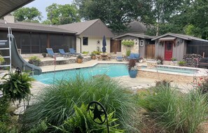 A backyard with a swimming pool, lounge chairs, and a small shed.