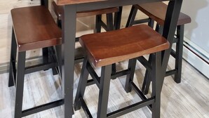 A wooden dining table with four matching stools.