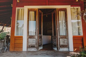 A wooden door with a white frame, leading into a room with patterned wallpaper. - Pousada Caminhos de Mel - Urubici - SC (Urubici)