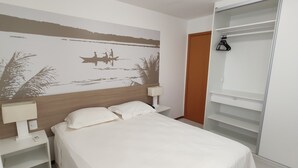 A bedroom with a bed, nightstands, a wardrobe, and a wall mural. - ILOA: Conforto, Natureza e Lazer (Barra de São Miguel)