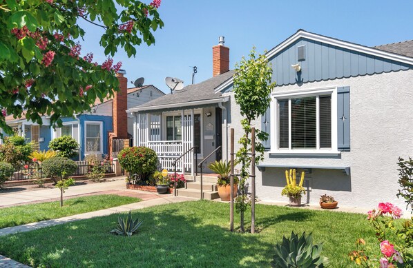 A residential neighborhood with houses featuring front porches, satellite dishes, and well-maintained lawns.