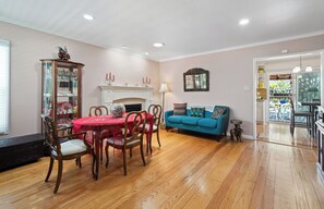 A dining area with a wooden table and chairs, a blue sofa, and a fireplace.