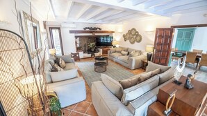 A spacious living area with a sofa set, a coffee table, and a television. - Private quiet villa with a short walk to beaches, restaurants, bars and shops. (Tías)