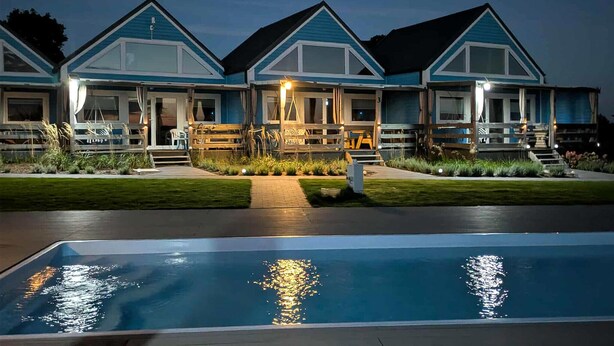 Ein modernes Haus mit Schwimmbecken im Vordergrund.