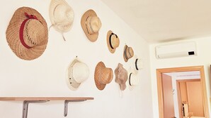 Una pared con varios sombreros colgados en ganchos.