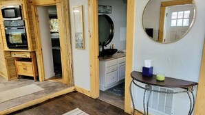 A compact kitchen with wooden cabinetry, a microwave, and a sink.