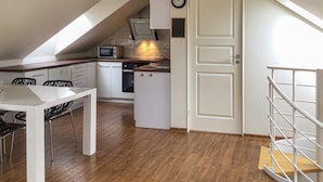 A compact kitchen with a dining area, a microwave, a dishwasher, and a clock on the wall. - 2 bedroom gorgeous home in åkersberga (Åkersberga)