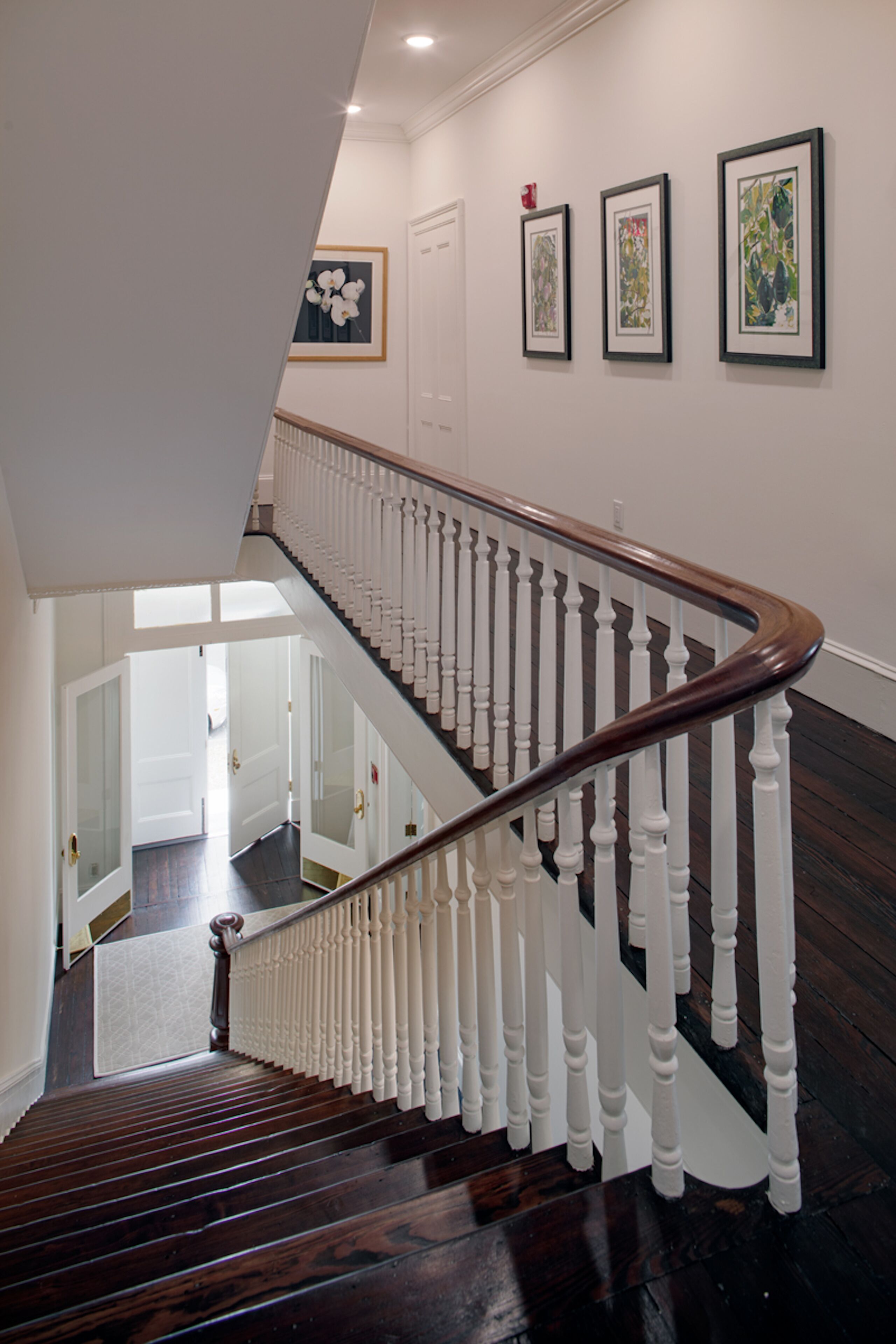 A staircase with white balusters and dark wooden steps leading to an upper floor.