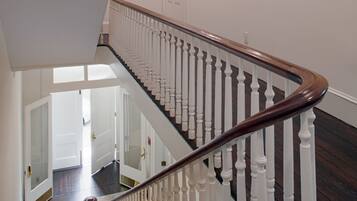 A staircase with white balusters and dark wooden steps leading to an upper floor.