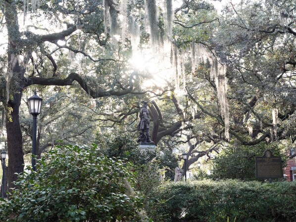 A statue in a park with a lamppost and a sign about James Edward Oglethorpe.