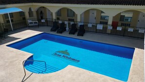 Una piscina con sillas de descanso y un cartel que dice 'Bas Misiones'.