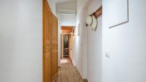 A narrow hallway with wooden doors and a herringbone-patterned floor. - Beach front home in Solanas, Sinnai with WiFi (Solanas, Sinnai)