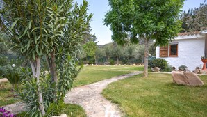 A stone pathway leading to a white building with a window and wooden shutters. - Beach front home in Solanas, Sinnai with WiFi (Solanas, Sinnai)