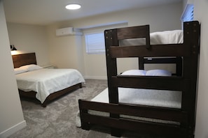 Cozy bedroom with a bunk bed, carpeted floor, and a bedside lamp.