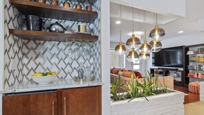 A kitchen with wooden cabinets, a marble countertop, and a backsplash with a chevron pattern.