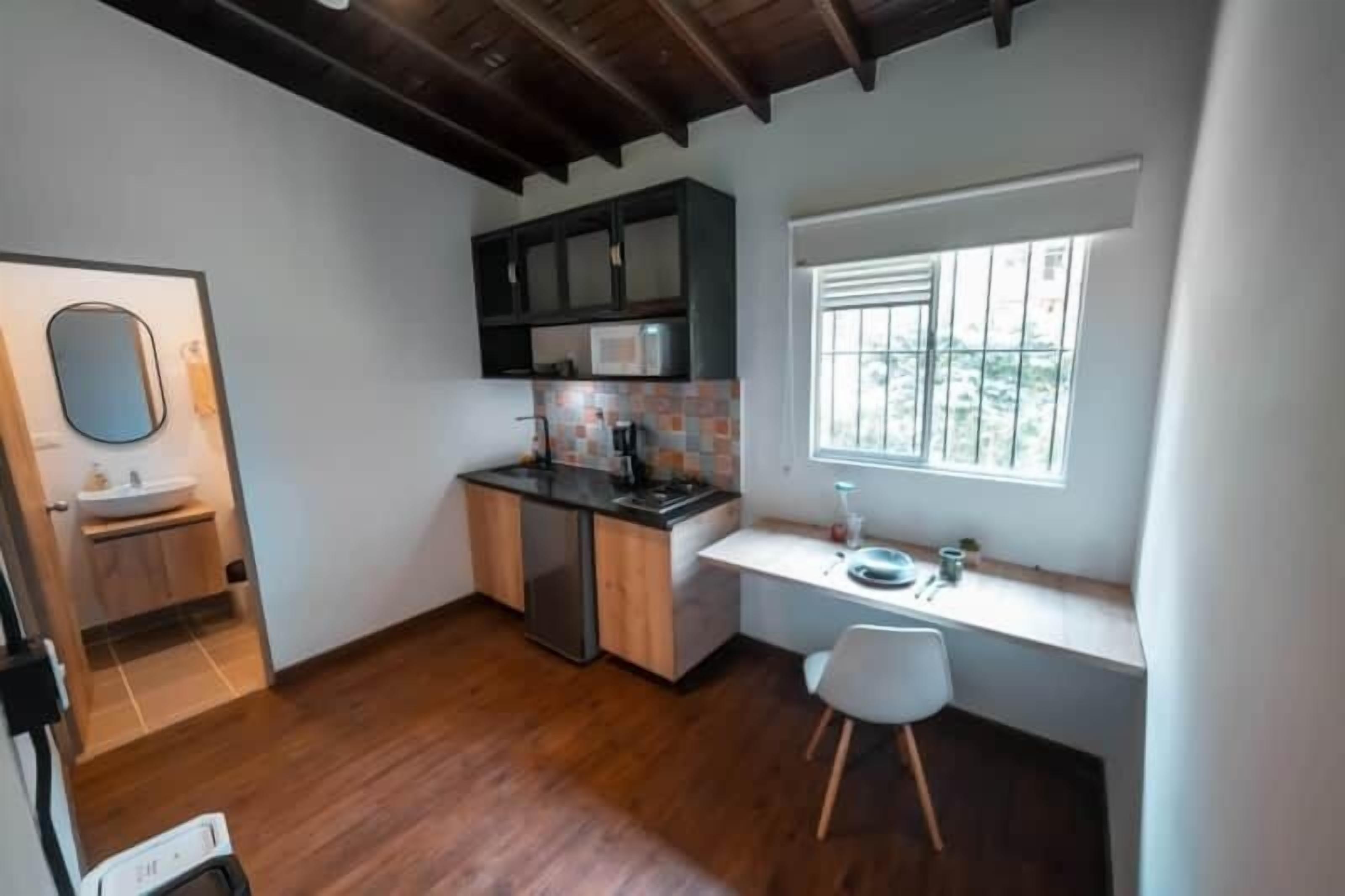 A compact kitchen with a built-in microwave, a sink, and a window for natural light.