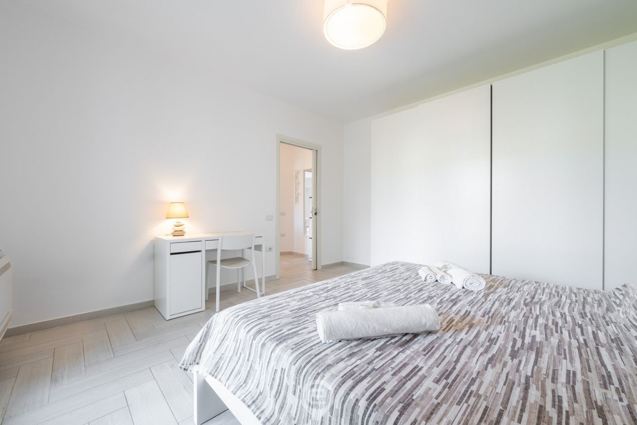 Une chambre à coucher moderne avec un lit, un bureau et une chaise.