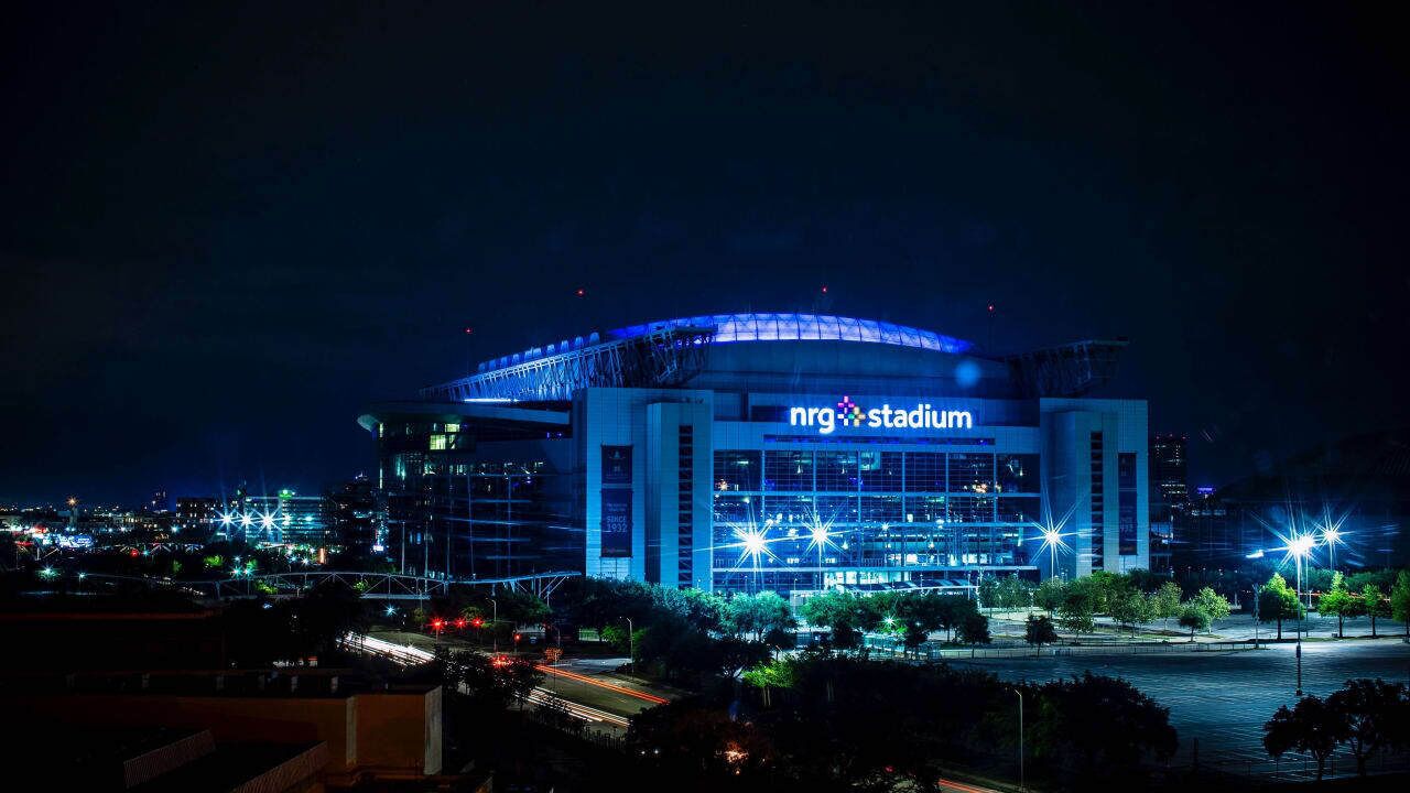 A stadium with a large, illuminated sign reading "nrg stadium" at night.