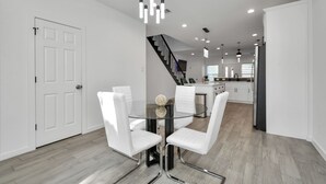 A modern kitchen with white cabinets, a black countertop, and a stainless steel refrigerator. - Grand Luxé Retreat: Lux Home ★ GATED ★ FREE PARKING ★ Medical Center & NRG (Houston)