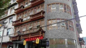 A multi-story building with traditional architectural elements, including ornate balconies and a curved facade. - Xuan En Jingyi Sunshine Inn (Xuan'en)