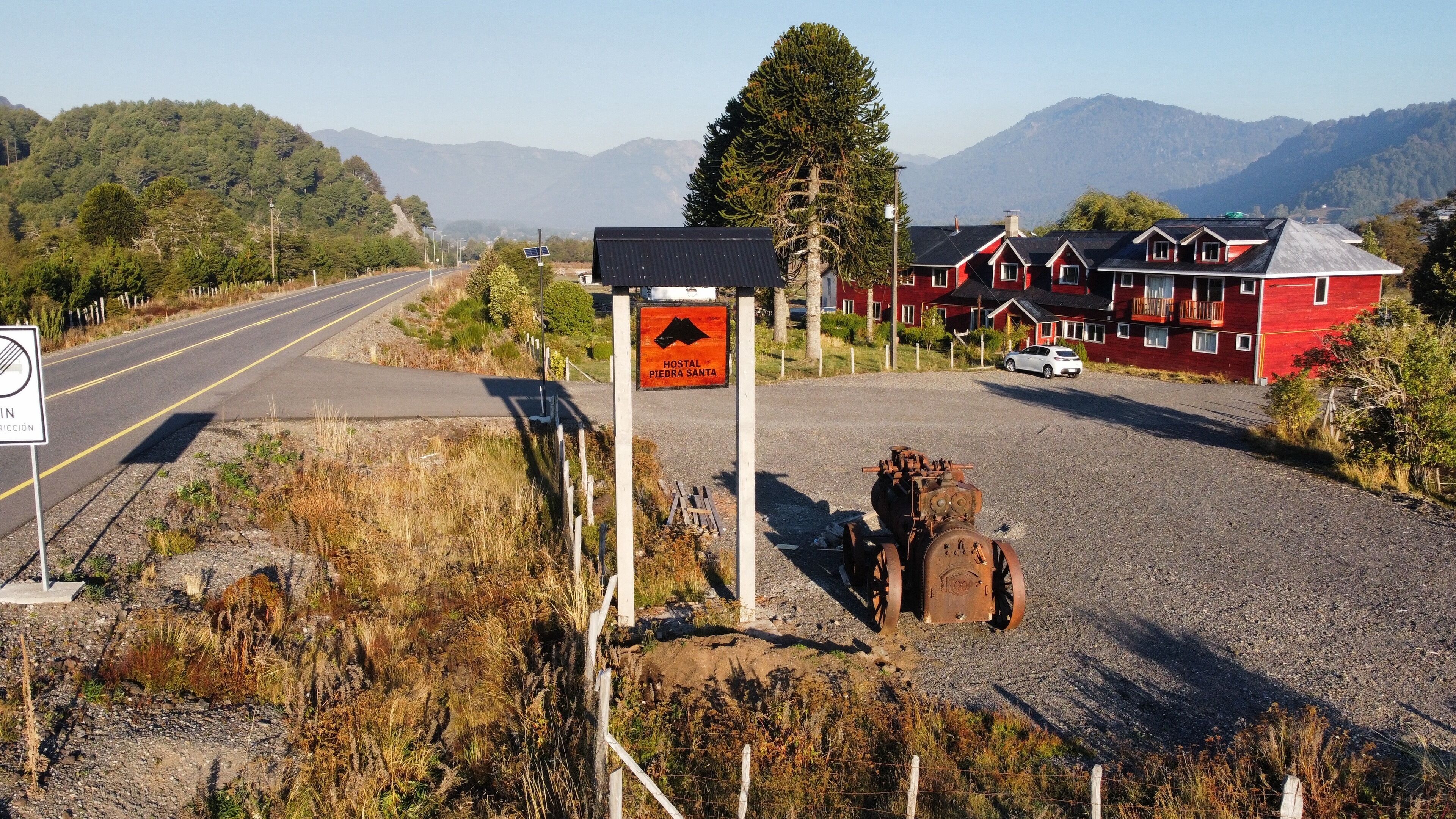 A red building with a sign indicating a hostel named Piedra Santa.