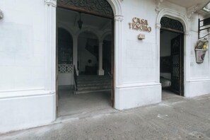 A building entrance with a sign reading 'CASA DE SORRO' and a staircase leading inside.