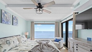 A bedroom with a bed, a ceiling fan, a view of the ocean, a chair, and a dresser. - Oceanfront Oasis | Indoor Pool | Hot Tub | Deck (Ocean City)