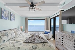 A bedroom with a bed, a ceiling fan, a view of the ocean, a chair, and a dresser. - Oceanfront Oasis | Indoor Pool | Hot Tub | Deck (Ocean City)