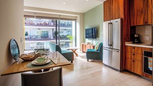 A modern kitchen with wooden cabinets, a built-in refrigerator, and a dining area with a table and chairs. - Beautiful condo in delightful Puerto Vallarta with pool, wifi & terrace views! (Puerto Vallarta)