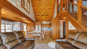A spacious living room with leather sofas, a dining table, and a kitchen in the background. - Waterfront Romulus Getaway w/ Private Dock! (Romulus)