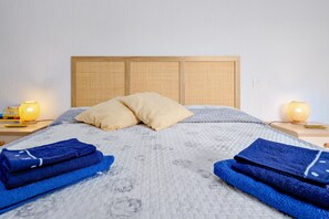 A neatly made bed with a headboard, two pillows, and folded towels. - Apartment 'Casa Vacanze Cannigione' with Private Terrace, Wi-Fi and Air Conditioning (Cannigione)