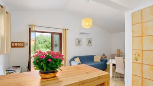 Ein gemütlicher Wohnbereich mit einem Holztisch, einem blauen Sofa und einem Esstisch mit Stühlen.