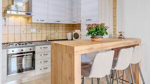 Eine moderne Küche mit einer Holzinsel, Edelstahlgeräten und einem Blumentopf.