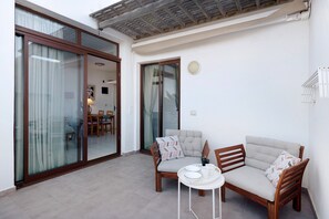 A room with a sliding glass door, a sofa, a small table with a tray, and a radiator.