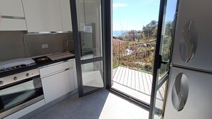 Eine moderne Küche mit Glastür und Zugang zu einem Balkon.