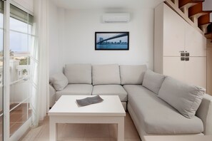 Een moderne woonkamer met een bank, een salontafel en een lijst met een afbeelding aan de muur.