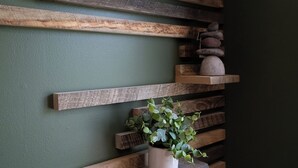 Una pared con estantes de madera y una planta en maceta.