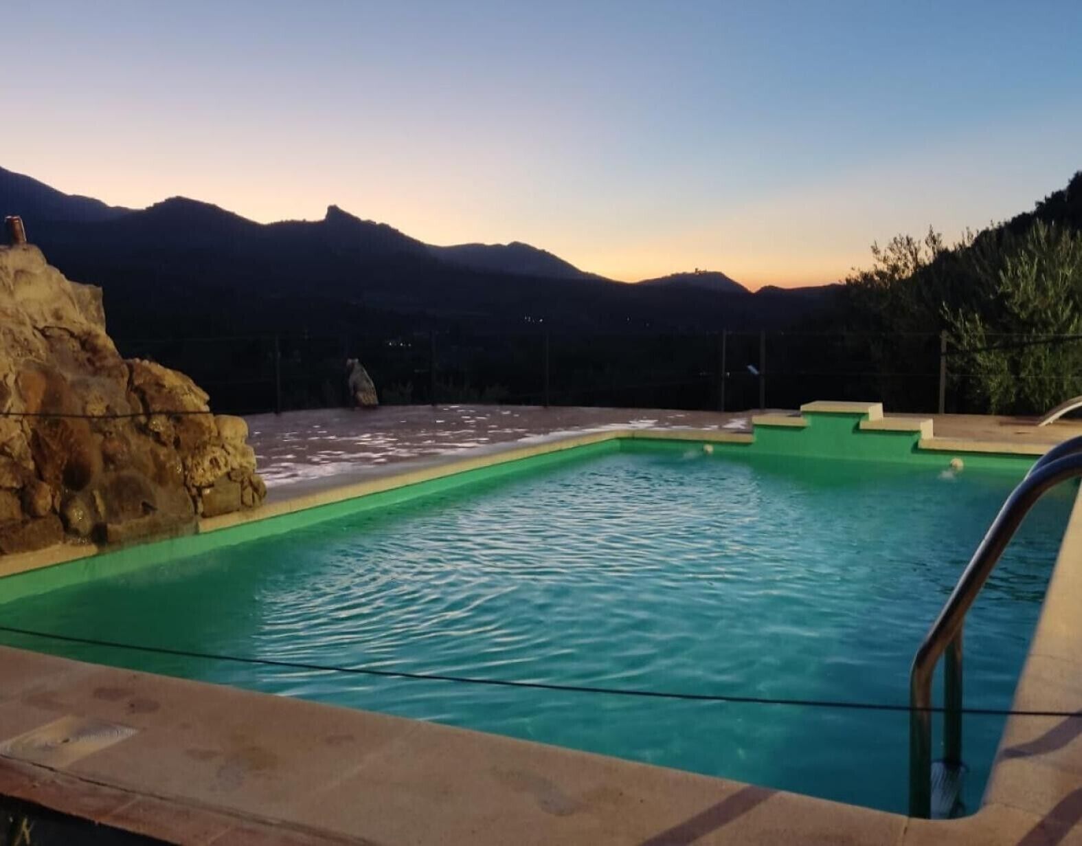 Una piscina con vistas a montañas al fondo.