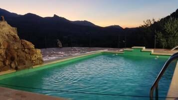 Una piscina con vistas a montañas al fondo.