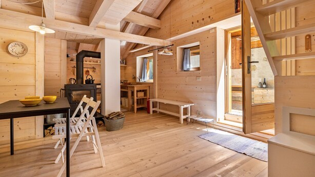 A wooden interior with a dining area, a bench, a fireplace, and a staircase. - Wunderchalet with Mountain Views, Private Grounds, and Terrace (valdaone)