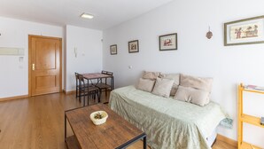 Quarto com cama, mesa de madeira e cadeira.