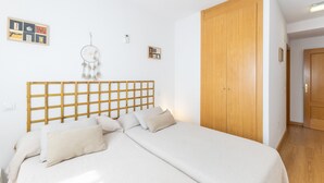 Quarto com cabeceira de madeira, cama com roupa de cama branca, guarda-roupa de madeira e um sonhoapanhado na parede.