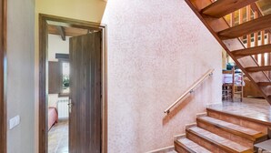 A staircase with wooden steps and a handrail, leading to a room with a door.