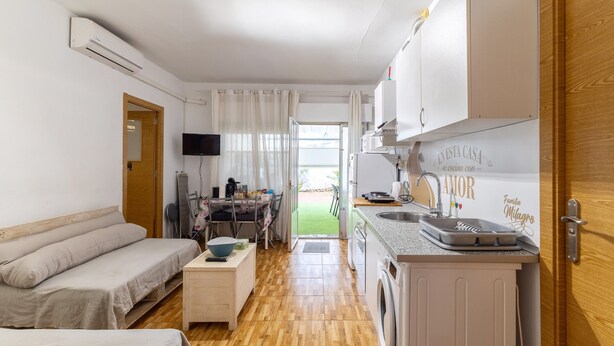 A compact living space with a kitchenette, a sofa, a dining area, and a view of the outdoors. - Sol y Luna Countryside Home with Pool near Toledo and Puy du Fou (Manzaneque)