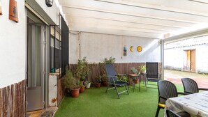 A patio with artificial grass, potted plants, a table, and chairs. - Sol y Luna Countryside Home with Pool near Toledo and Puy du Fou (Manzaneque)